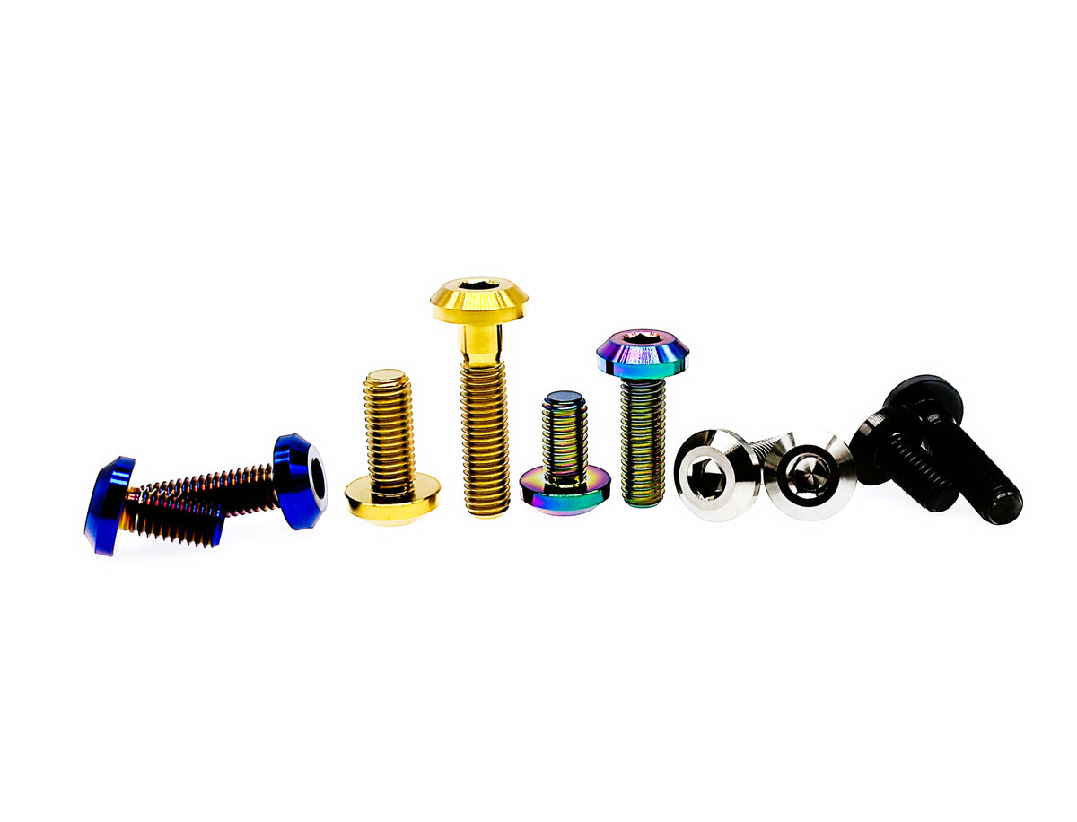 Titanium M8 and M8 umbrella head bolts laid on their sides in five anodized finishes